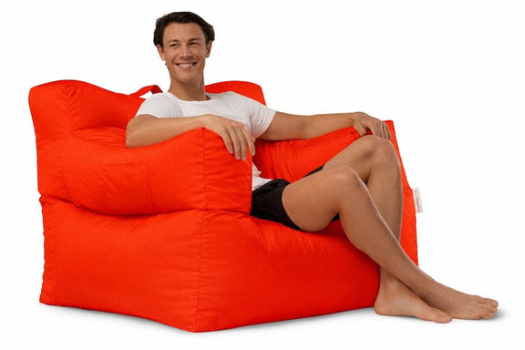 man sitting on a bright red armchair beanbag