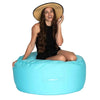 Woman wearing a straw hat sitting on a large blue bean bag ottoman.