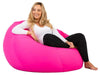 Woman sitting on a pink bean bag chair against a white background