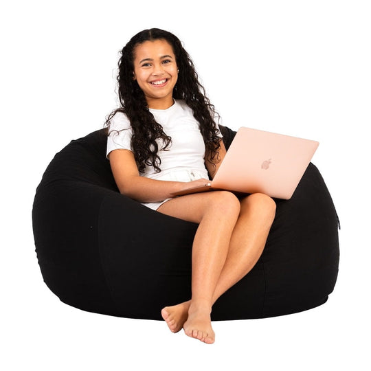 teenage girl sitting on a black cotton beanbag chair