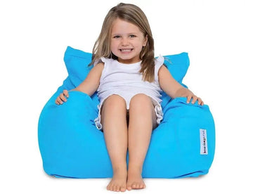 Child sitting on a blue bean bag chair against a white background