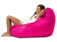 Young girl sitting in a bright pink bean bag chair on a white background