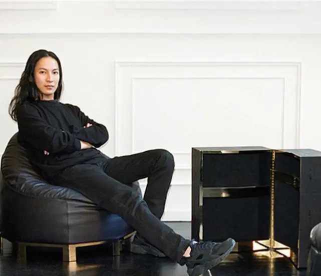 Person sitting on a black leather chair in a modern interior setting
